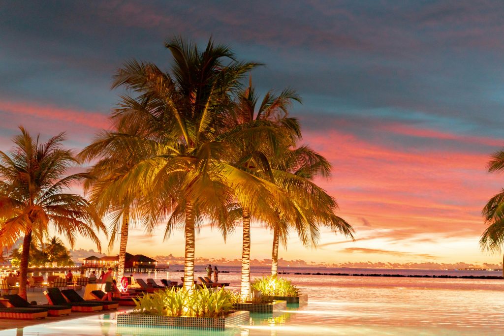 Experience ultimate relaxation at a tropical resort paradise during a breathtaking sunset.